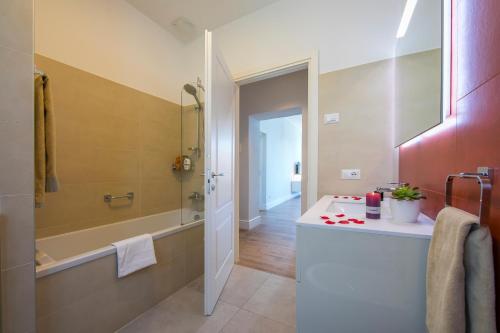 y baño con bañera, lavamanos y ducha. en Casa Maria Menaggio, en Menaggio