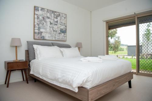 a bedroom with a large white bed with a window at Triple Creek Guest House - Barossa Region in Seppeltsfield