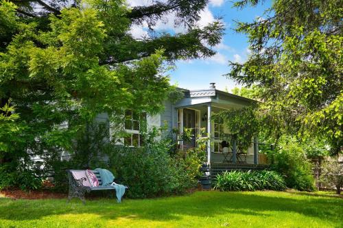 a white house with a bench on a yard at Foxmere in Daylesford