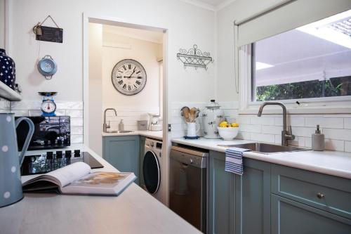 a kitchen with a sink and a clock on the wall at Foxmere in Daylesford
