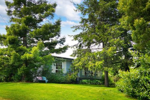 a white house with trees in a yard at Foxmere in Daylesford