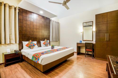 1 dormitorio con 1 cama grande y escritorio en FabHotel Aashraye en Nueva Delhi