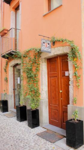 a building with a brown door and two potted plants at Sa Domo De Alene in Bosa