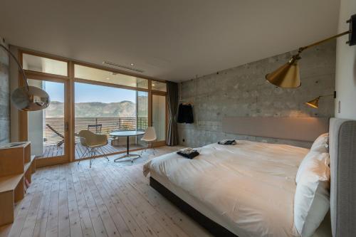 een slaapkamer met een groot bed en een balkon bij Hakone Honbako 箱根本箱 in Hakone