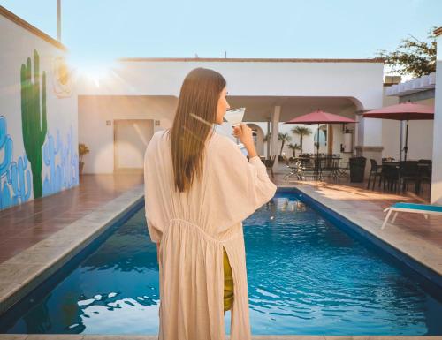 una mujer parada frente a una piscina en Hotel Buen Valle en Torreón