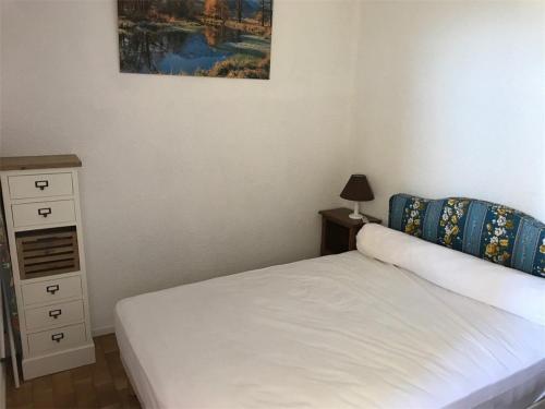 - une chambre avec un lit, une commode et un tableau dans l'établissement Appartement T2 Cabine 6 pers en bord de mer, parking privé, proche commerces et plage - Leucate - FR-1-81-49, à Port-Leucate