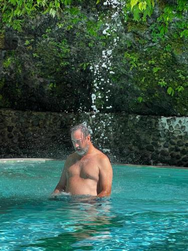 een man in het water in een zwembad bij Azure at Tranquility Bay Beach Resort in Kinabutan