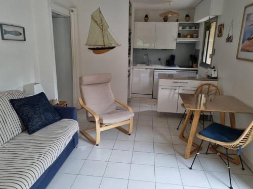 un salon avec un canapé et une table et une cuisine dans l'établissement Arcachon, Ville de Printemps - Appartement T2 avec Jardin à 250m des Plages - FR-1-433-91, à Arcachon