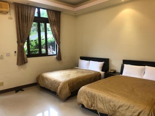 Una habitación de hotel con dos camas y una ventana. en Country Homestay, en Guoxing