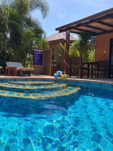 a swimming pool with blue water in a resort at Panisara Pool Villa Resort Huahin in Hua Hin