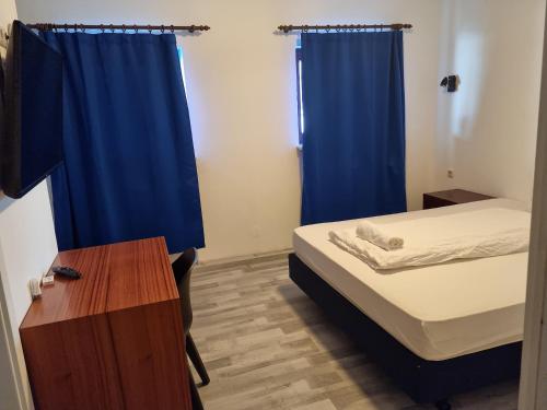 a small room with a bed and a blue curtain at City Centre Unterkunft in Itzehoe