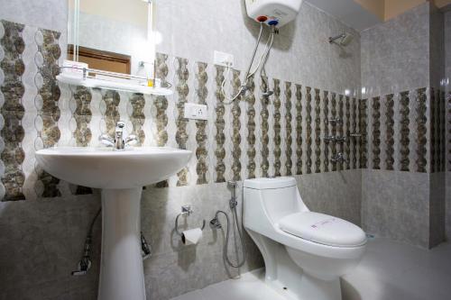 y baño con aseo blanco y lavamanos. en Golden Oren Hotels and Spa, en Darjeeling
