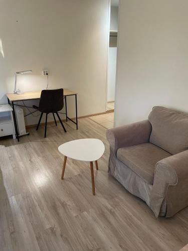 a living room with a couch and a table and a desk at Lapin Satu in Posio