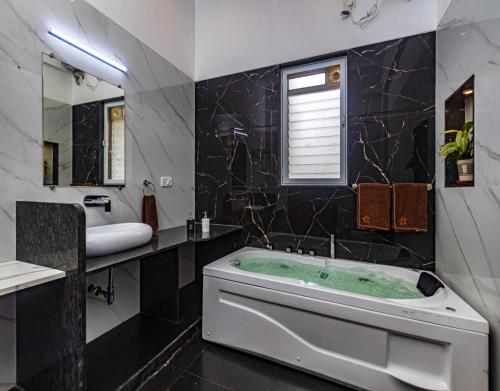 a bathroom with a tub and a sink at SaffronStays Casa Delizia, Lonavala in Lonavala