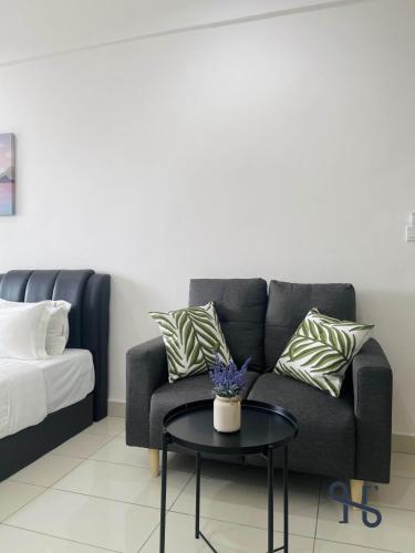 a living room with a couch and a table at Homesuite' Home at Aeropod SOVO in Kota Kinabalu