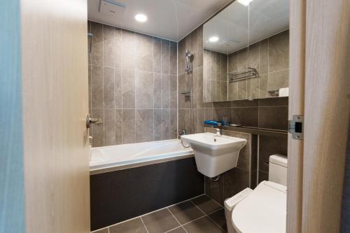 a bathroom with a toilet and a sink and a bath tub at Hotel The Blue Terra in Sokcho