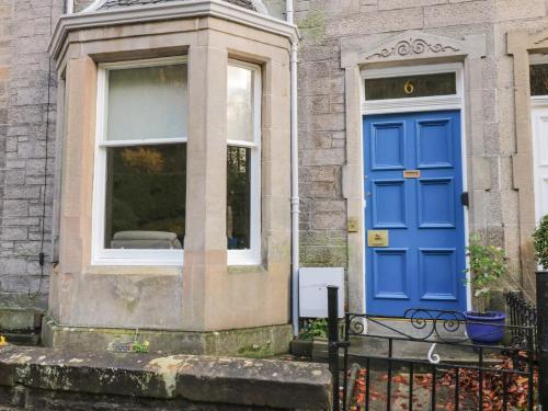a blue door on a house with a window at 6 Coltbridge Gardens in Edinburgh