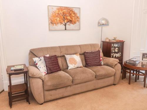 a living room with a brown couch with pillows at 6 Coltbridge Gardens in Edinburgh