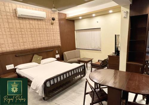 a hotel room with a bed and a table and a projector at Royal Palms Luxury Service Apartment in Nagpur