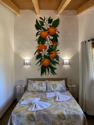a bedroom with a large painting of oranges on the wall at Finca Aquilino y Carmen in Mogán