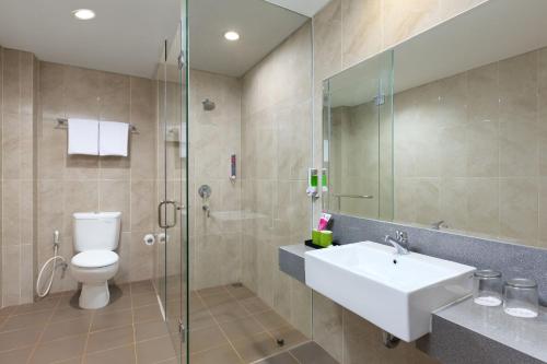 ein Bad mit einem WC, einem Waschbecken und einer Dusche in der Unterkunft favehotel Kediri in Kediri