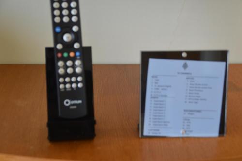 a remote control sitting next to a sign on a table at Aturukan Hotel in Kitale