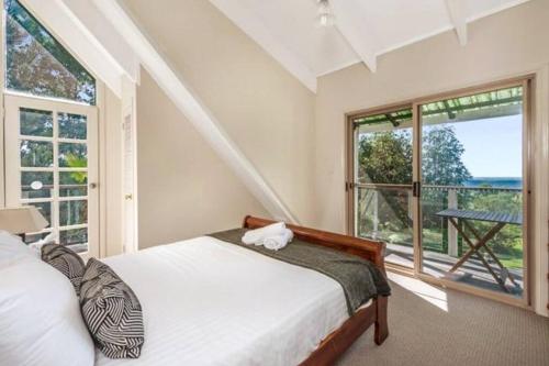 タンボリーン・マウンテンにあるSpectacular Gold Coast Skyline Viewsのベッドルーム1室(ベッド1台、大きな窓付)