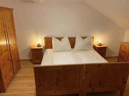 a bedroom with a large wooden bed with two night stands at Sonnenhof in Kals am Großglockner