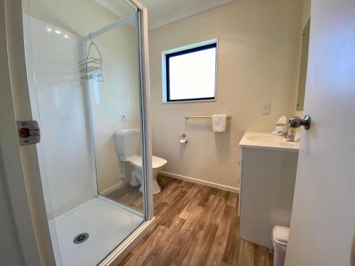 a bathroom with a shower and a toilet and a sink at Apartment Style Holiday Home in Twizel