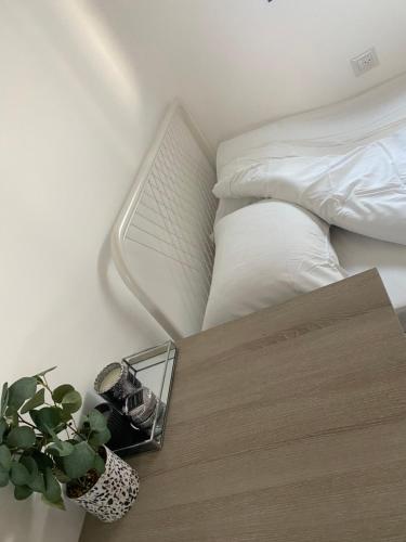 Un dormitorio con una cama y una mesa con una planta en אמור, en Beer Sheva