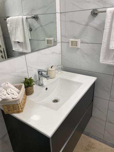 y baño con lavabo blanco y espejo. en אמור, en Beer Sheva