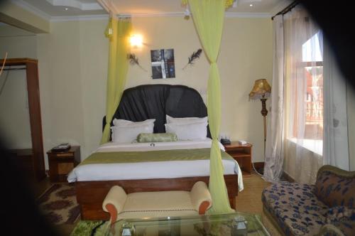a bedroom with a bed and a chair and a couch at Aturukan Hotel in Kitale