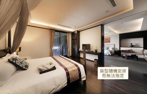 a bedroom with a large bed and a living room at Spring Hill Resort in Tianliao