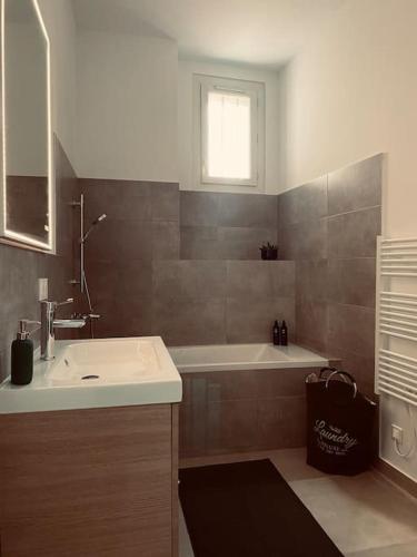 une salle de bain avec un lavabo et une baignoire dans l'établissement Au cœur de Marseille : superbe appartement !, à Marseille