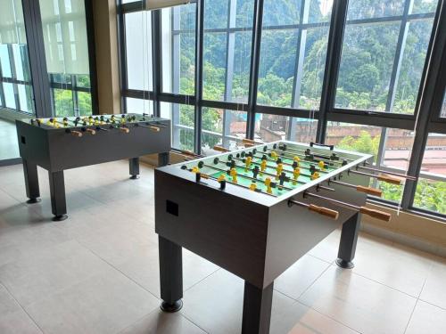 two foosball tables in a room with windows at Sunway Onsen Theme Park View @Lost World of Tambun in Ipoh