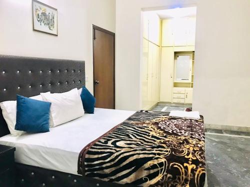 a bedroom with a large bed with blue pillows at Hotel Rose Inn Lahore in Lahore
