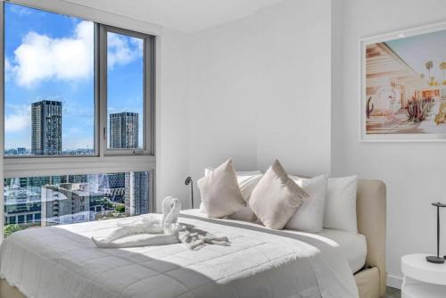a white bedroom with a bed with a window at Modern 1 Bed Condo across from Bayside in Downtown in Miami