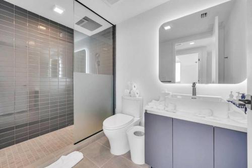 La salle de bains est pourvue de toilettes, d'un lavabo et d'une douche. dans l'établissement Modern 1 Bed Condo across from Bayside in Downtown, à Miami