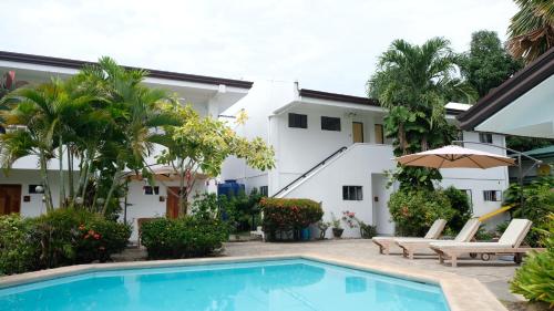 eine Villa mit einem Pool und einem Haus in der Unterkunft Red Knight Gardens in Davao City