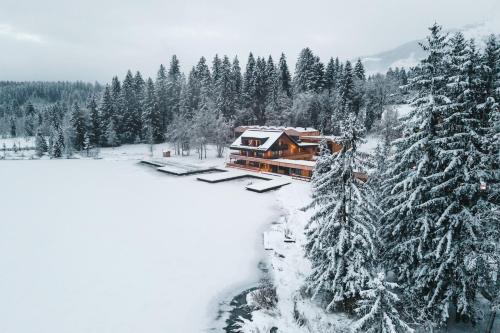 a lodge in the snow with snow covered trees at Alpenhotel Kitzbühel am Schwarzsee - 4 Sterne Superior in Kitzbühel