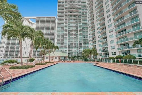 a swimming pool in front of a large apartment building at Amazing Loft style 1 Bed with Water and City Views in Miami