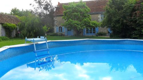 une grande piscine bleue devant une maison dans l'établissement Large family house for young and old in great calm in South Touraine, à Cussay