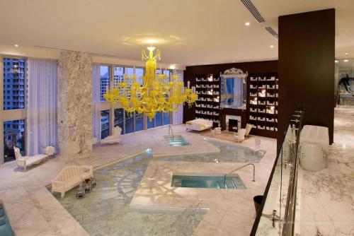 a large living room with a chandelier and a pool at Beautiful One Bedroom Condo 16ft ceilings at the W in Miami