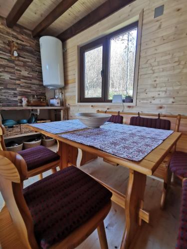 a dining room with a wooden table and chairs at Casuta dintre nuci in Blăjeni