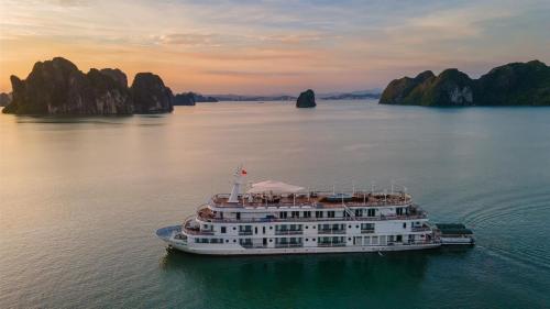 a cruise ship in halong bay at sunset at Paradise Elegance Cruise Halong in Ha Long