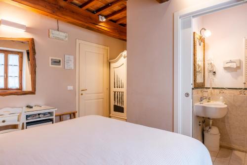 een slaapkamer met een wit bed en een wastafel bij Villa Maria - b&b di Charme in Vicopisano
