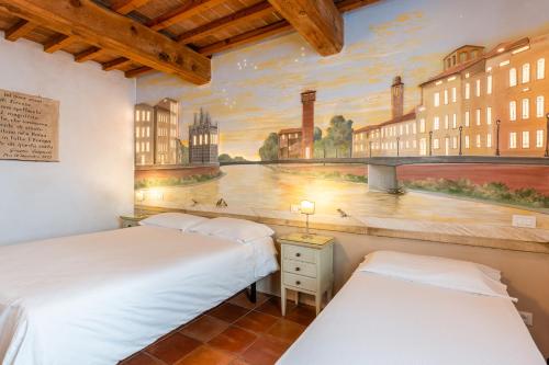 two beds in a room with a painting on the wall at Villa Maria - b&b di Charme in Vicopisano
