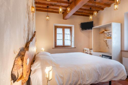 a bedroom with a white bed and a tv at Villa Maria - b&b di Charme in Vicopisano