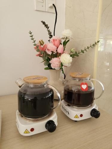 a couple of tea makers sitting on a table with flowers at BB Hotel&Resort in Phu Quoc