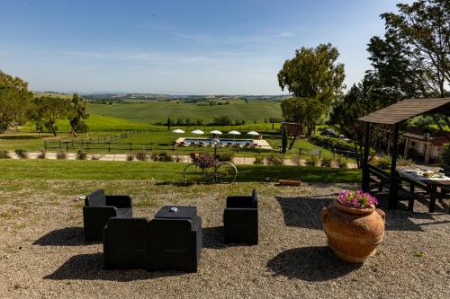 a garden with a large vase and a view of a field at Wine Resort Colsereno in Montalcino